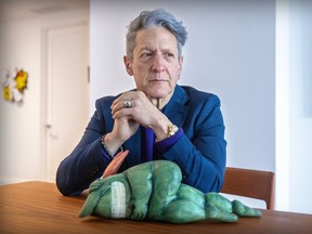 Just for Laughs co-founder Andy Nulman sits at a table witgh his hands clasped and a doll of the festival mascot lying on its side on the table.