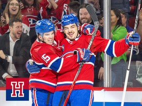 Two Montreal Canadiens celebrate a goal in front of their fans