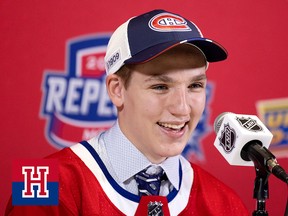 A young man wearing a hockey jersey over his suit and tie speaks into a microphone during a press conference