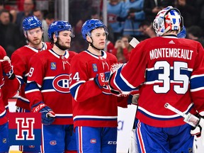 A row of players waits to high five Montreal Canadiens goaltender Samuel Montembeault, who is seen from behind