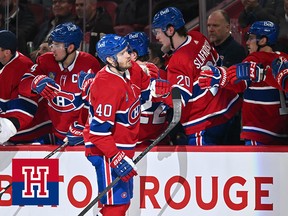 A Montreal Canadiens player fist bumps his teammates on the bench after scoring a goal