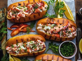 Three very colourful lobster rolls are seen from above in this photo.