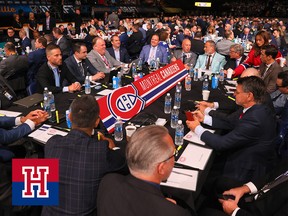 A group of men in suits sits around a table with the Montreal Canadiens logo