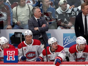 Martin St. Louis stands with his arms crossed behind the Montreal Canadiens bench