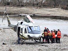 Rescuers carry the body of one of the two missing firefighters to a helicopter, May 3, 2023, in Baie-St-Paul, Que.