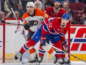 Canadiens' Arber Xhekaj, foreground, and David Savard jostle with Philadelphia Flyers Garnet Hathaway in front of Canadiens goalie Cayden Primeau in Montreal on Thursday March 28, 2024.