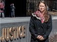 Anastasia Boldireff stands in front of the word 'justice' on a sign outside the courthouse