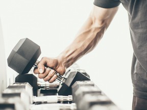 Unrecognizable man taking dumbbells in a gym