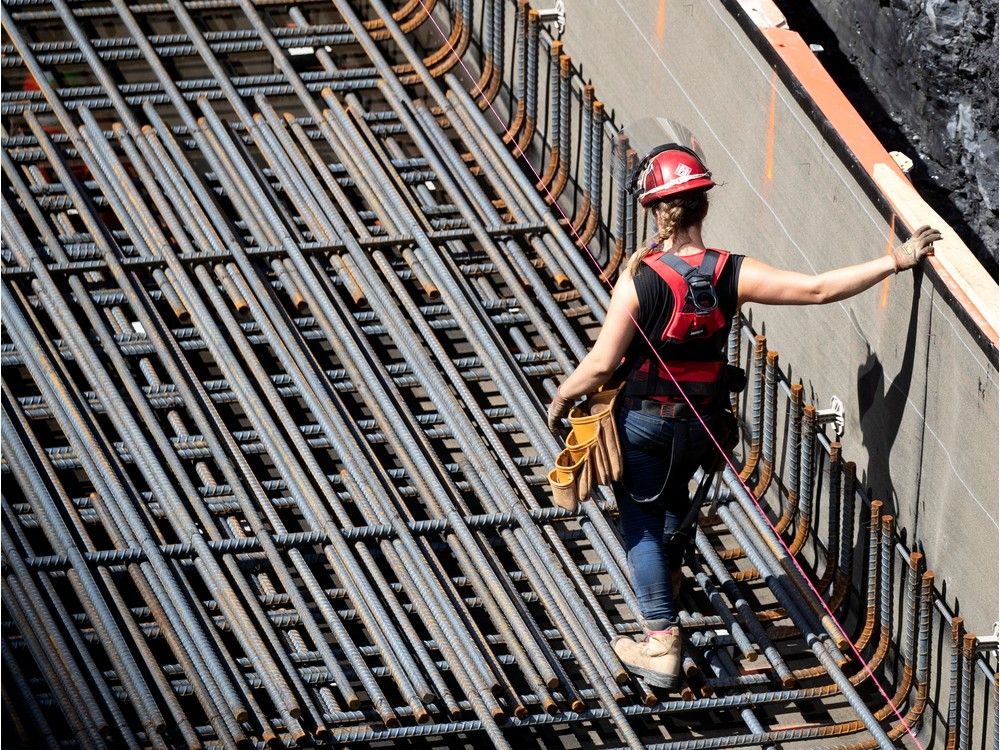A female construction worker installs rebar on a new condo project in Montreal on Aug. 12, 2020. 