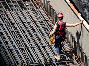 A female construction worker walks on rebar on a worksite