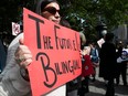 A protester holds a sign that says "The Future Is Bilingual"