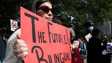 A protester holds a sign that says "The Future Is Bilingual"