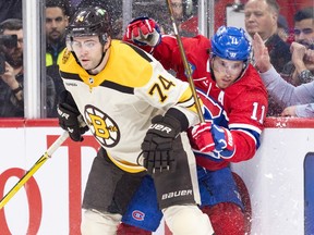 Canadiens' Brendan Gallagher is squeezed into the boards by Bruins' Jake DeBrusk during first period Thursday night at the Bell Centre.