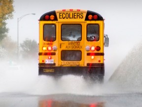 A school bus kicks up water spray