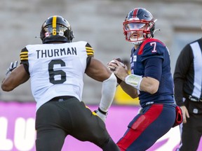 Alouettes QB Cody Fajardo looks for a reciever while under pressure from Tiger-Cats linebacker Jameer Thurrman during East semifinal last November.