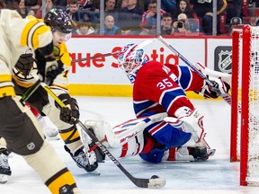 Bruins' Jake DeBrusk extends his stick to slide the puck past Canadiens goalie Sam Montembeault for the winning goal.,