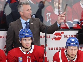 Canadiens coach Martin St. Louis calls to goaltender Sam Montembeault during game last year as Jake Evans, left, and Jesse Ylönen look on.