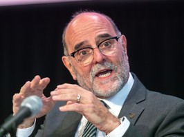 Montreal director general Serge Lamontagne speaks at a microphone while raising his hands.