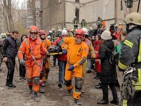 Rescuers carry a body at the site of a heavily damaged multi-story apartment building, following a Russian drone attack, in Odesa, on March 2, 2024.