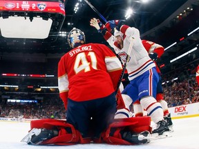 In a photo taken from inside the net, Panthers goalie Anthony Stolarz is seen resting on his knees, while in front of him Canadiens' David Savard raises his arms in the air in celebration after a Montreal goal.