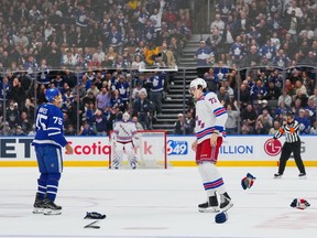 Maple Leafs' Ryan Reaves, left, and Rangers' Matt Rempe prepare for a fight at centre ice during the third period at Scotiabank Arena in Toronto on Saturday.