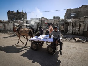 Palestinians transport sacks of flour distributed by the UN in the Rafah refugee camp in the southern Gaza Strip, on March 21, 2024, amid ongoing battles between Israel and the militant group Hamas.