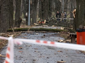 Local residents walk near the site of a rocket strike in one of the parks after a Russian missile attack in Kyiv, on March 24, 2024, amid the Russian invasion in Ukraine.