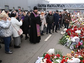 An Orthodox priest leads a service at a makeshift memorial in front of the burnt-out Crocus City Hall concert venue in Krasnogorsk, outside Moscow, on March 26, 2024.