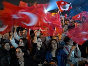 Opposition Republican People's Party (CHP) supporters wave Turkish national flags as they celebrate outside the main municipality building following municipal elections across Turkey, in Istanbul on Sunday, March 31, 2024.