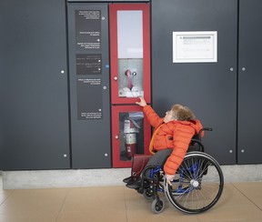 Marie Turcotte gets a closer look at the emergency calling section of the REM station in Brossard on Friday, Feb. 16, 2024.