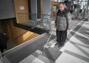 Serge Poulin tries to makes sense of the markings on the floor of the REM station in Brossard on Friday, Feb. 16, 2024.