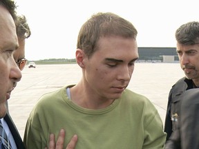 Luka Magnotta is escorted by police after arriving at Quebec's Mirabel Airport from Germany on June 18, 2012.