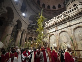 Pierbattista Pizzaballa, the Latin Patriarch of Jerusalem, centre walks in a procession during the Palm Sunday Mass in the Church of the Holy Sepulchre, where many Christians believe Jesus was crucified, buried and rose from the dead, in the Old City of Jerusalem, Sunday, April 2, 2023.
