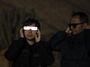 People watch a total solar eclipse in La Higuera, Chile, Tuesday, July 2, 2019.
