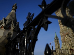 The Peace Tower of Parliament Hill is pictured through the iron fence along Wellington St. in Ottawa on Tuesday, Feb. 27, 2024.