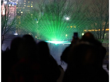 People watch a laser show that is meant to replicate the Northern Lights during a nuit blanche in the Old Port in Montreal on Saturday, March 2, 2024.