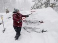 Janna Gunnels digs out her car as snow continues to fall in Tahoe City, Calif., on Saturday, March 2, 2024.