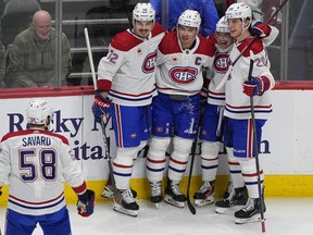 Canadiens defenceman David Savard heads over to congratulate centre Nick Suzuki, second from left, after his goal against the Avalanche Tuesday night in Colorado. Congratulating Suzuki are, from left, defenceman Arber Xhekaj, wingers Cole Caufield and Juraj Slafkovsky.