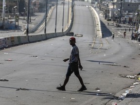 A pedestrian crosses a street free of traffic in Port-au-Prince, Haiti, Wednesday, March 13, 2024.