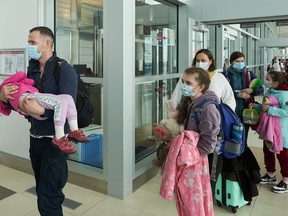 Ukrainian nationals fleeing the ongoing Russian invasion of Ukraine arrive in at the Richardson International Airport in Winnipeg on May 23, 2022.