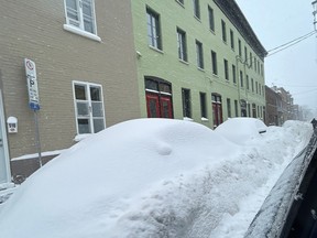 Cars are buried under a heavy layer of snow on a downtown street in Quebec City on Jan. 10, 2024.