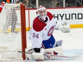 Canadiens goaltender Jake Allen is seen crouching down on his knees and hugging the right post.