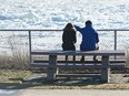 Two people sit on a bench