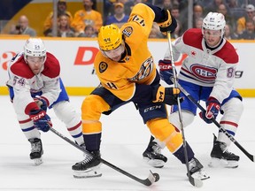 Canadiens defenceman Jordan Harris, left, hits the puck away from Predators' Kiefer Sherwood while Habs' Joshua Roy watches the action.