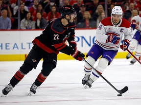 Hurricanes' Brett Pesce, left, controls the puck in front of Canadiens captain Nick Suzuki during third-period action Thursday night in Raleigh, N.C.