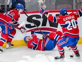 Canadiens' Mike Matheson (8) celebrates with teammates Cole Caufield (22) and Juraj Slafkovsky (20) after scoring against the Toronto Maple Leafs during first period NHL hockey action in Montreal on Saturday, March 9, 2024.