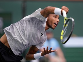 Montreal's Félix Auger-Aliassime serves against Carlos Alcaraz, of Spain, at the BNP Paribas Open tennis tournament in Indian Wells, Calif., on Sunday, March 10, 2024.