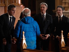 Mark Mulroney, from left, Ben Mulroney and Nicolas Mulroney speak with a member of the public yesterday at Saint Patrick's Basilica.