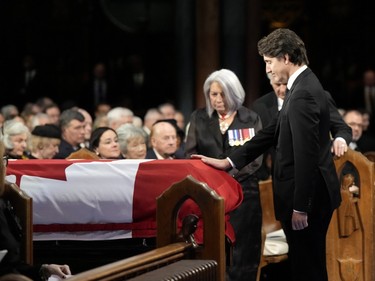 Prime Minister Justin Trudeau places his hand on the casket during the funeral of former prime minister Brian Mulroney, in Montreal, Saturday, March 23, 2024.