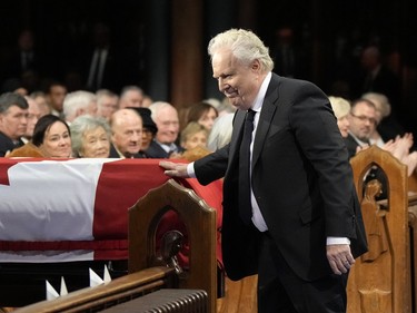 Former Quebec premier Jean Charest touches the casket during the funeral of former prime minister Brian Mulroney, in Montreal, Saturday, March 23, 2024.